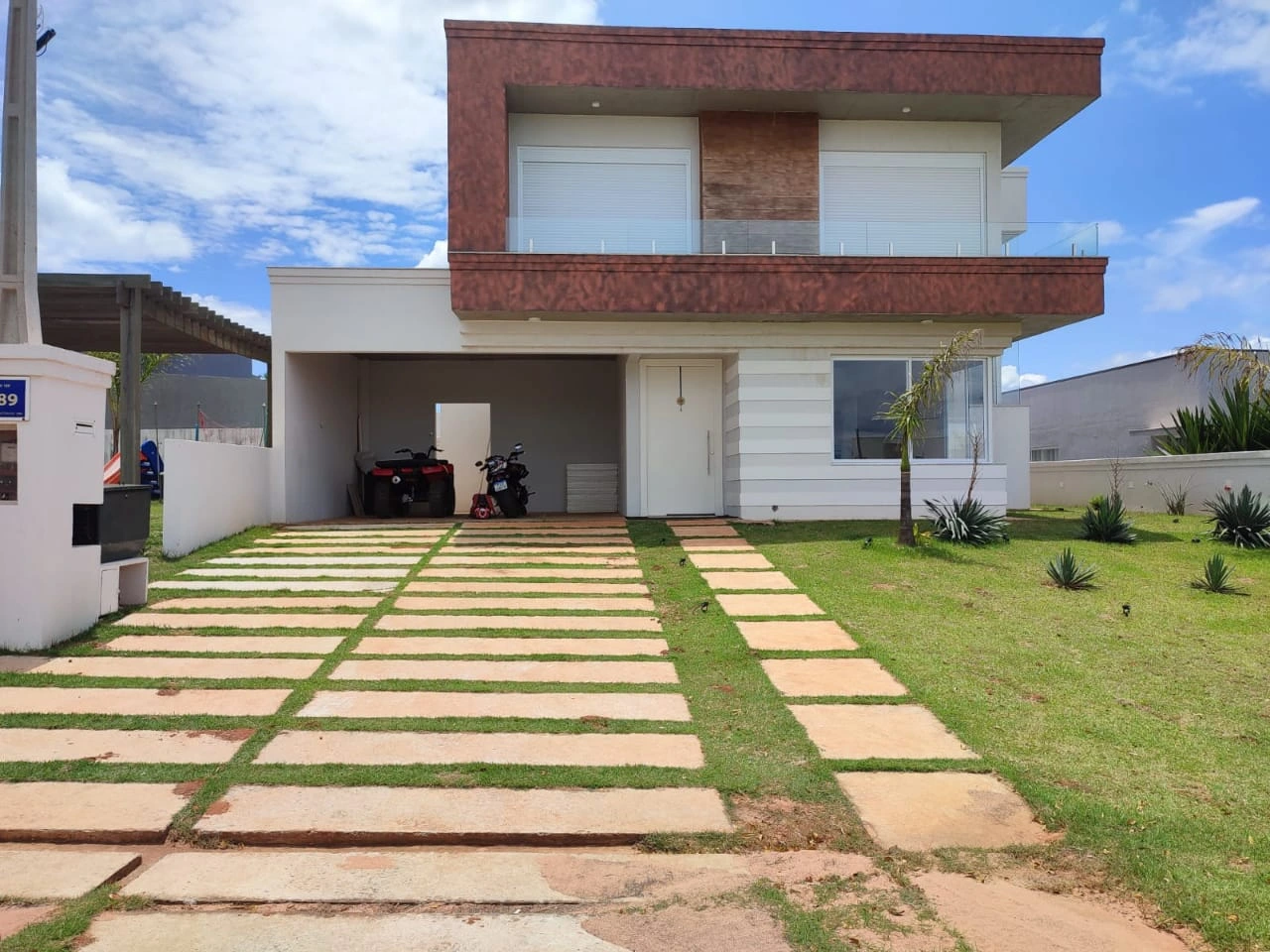 Fachada frontal com jardim casa entregue em Riviera